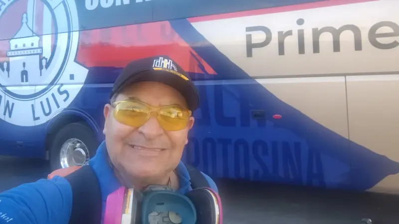 Fumigador profesional tomandose una foto con un autobus del Atletico de San Luis con su equipo de fumigación