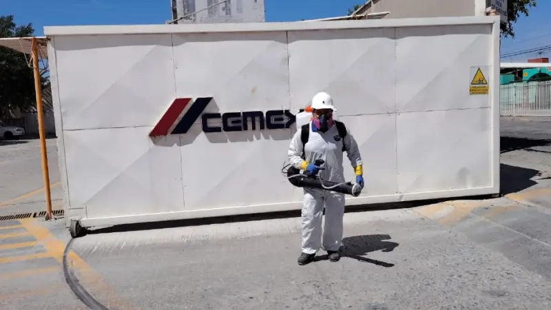 Fumigador por fuera de Cemex con traje blanco, herramienta para fumigar