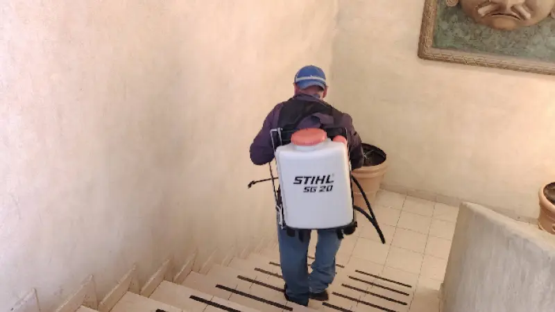 Fumigador bajando escaleras de un edificio de oficina en San Luis Potosí