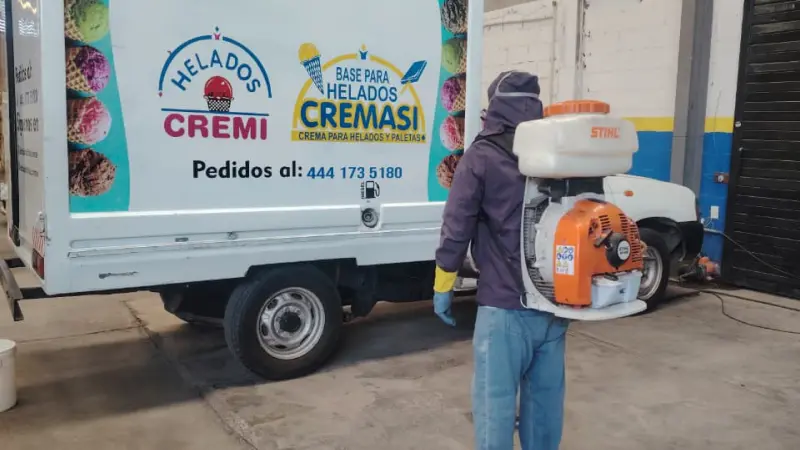 Hombre fumigando camión de helados en un almacén en San Luis Potosí